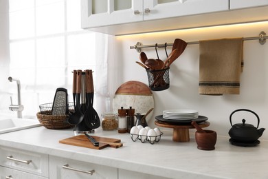 Set of different utensils and dishes on countertop in kitchen