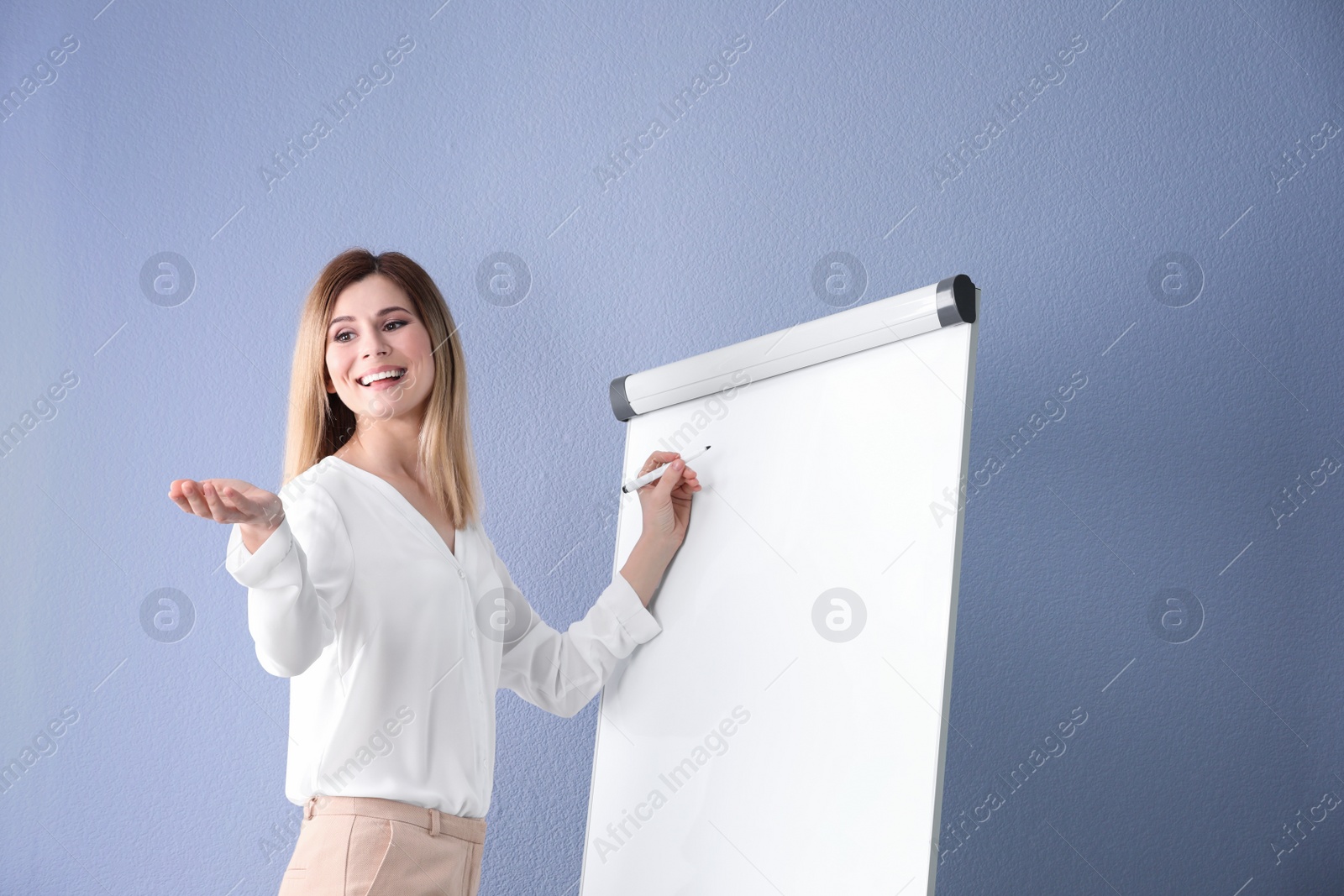 Photo of Female business trainer giving presentation against color background