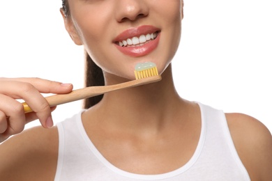 Photo of Woman holding toothbrush with paste on white background, closeup