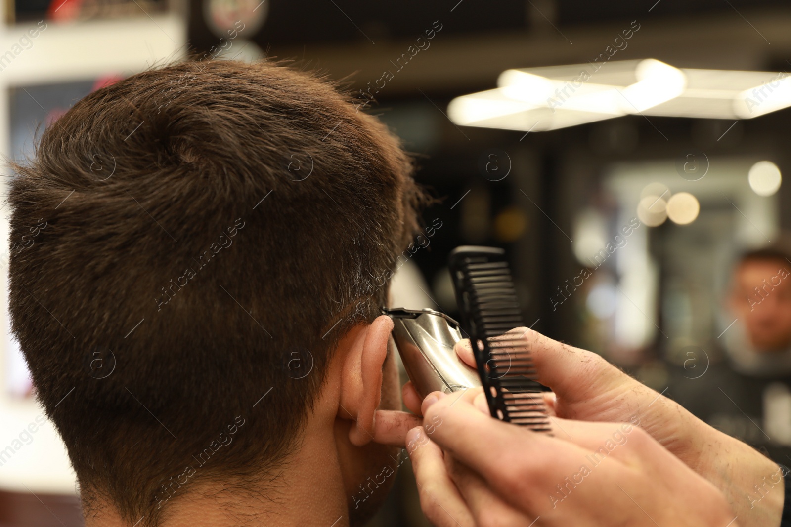 Photo of Professional hairdresser making stylish haircut in salon, closeup