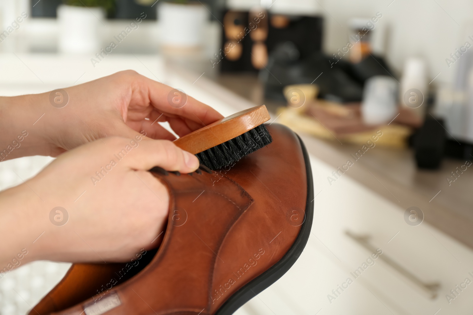 Photo of Woman cleaning stylish footwear indoors, closeup. Shoe care accessories