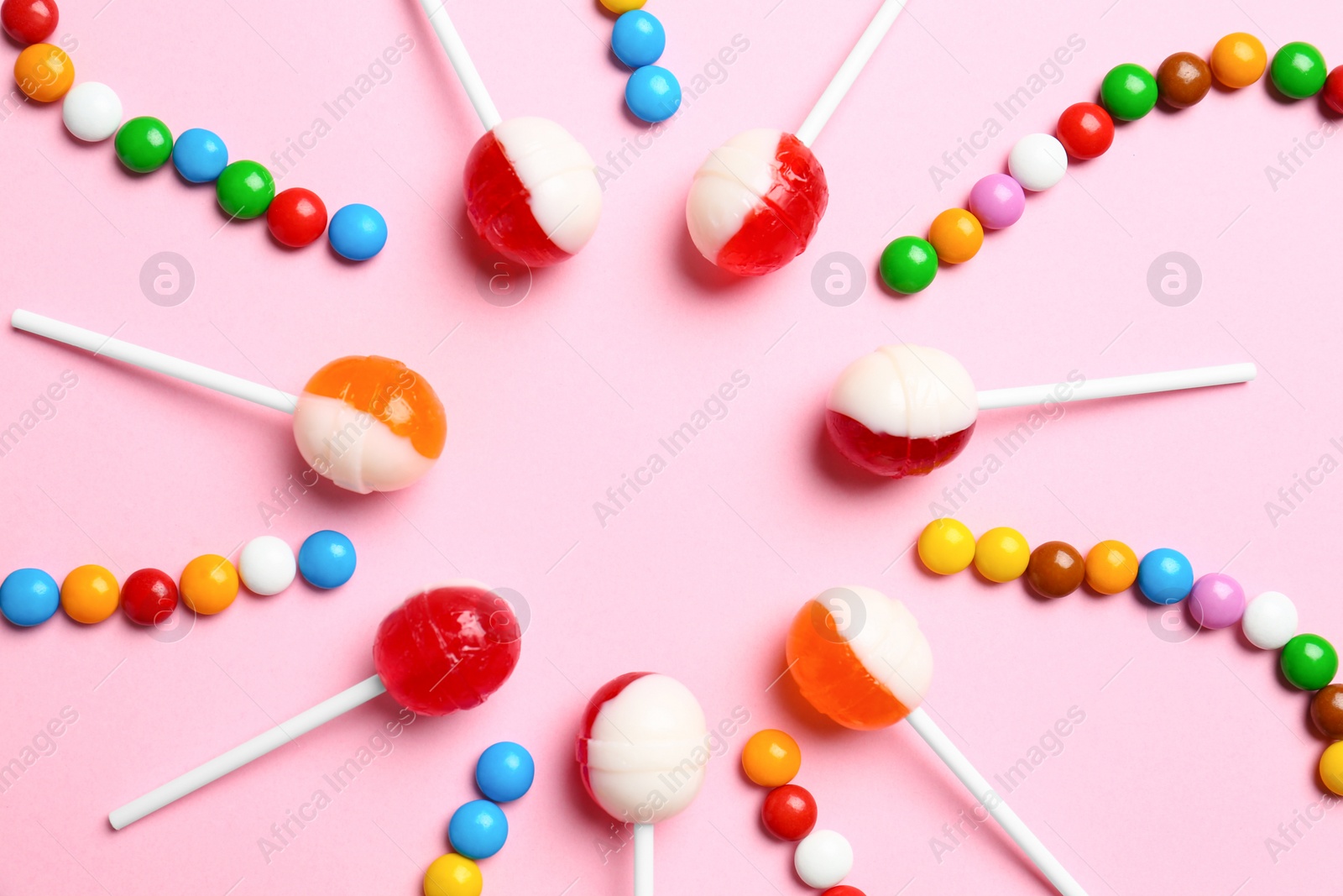 Photo of Flat lay composition with different candies on pink background. Space for text