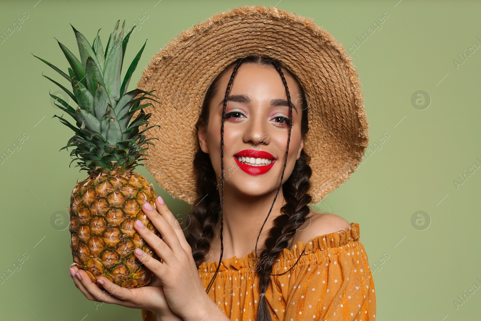 Photo of Young woman with fresh pineapple on olive background. Exotic fruit