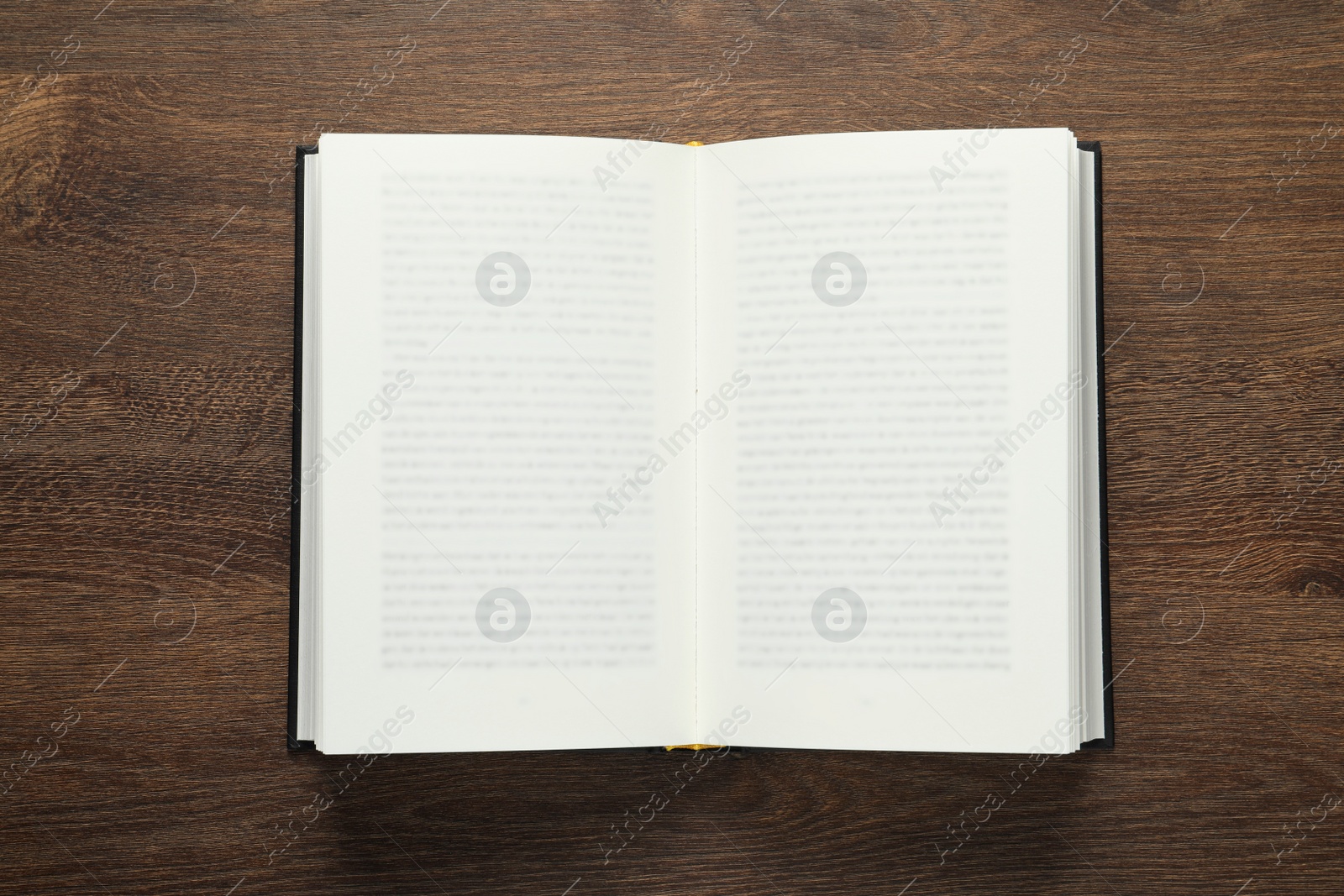 Photo of Open book on wooden table, top view