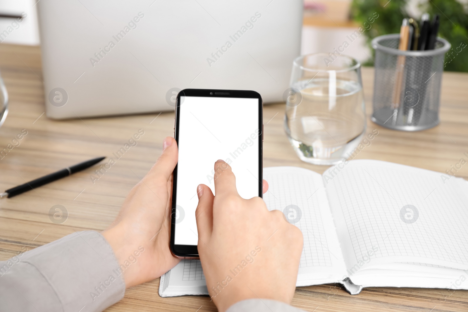 Photo of Woman with modern smartphone at wooden table, closeup