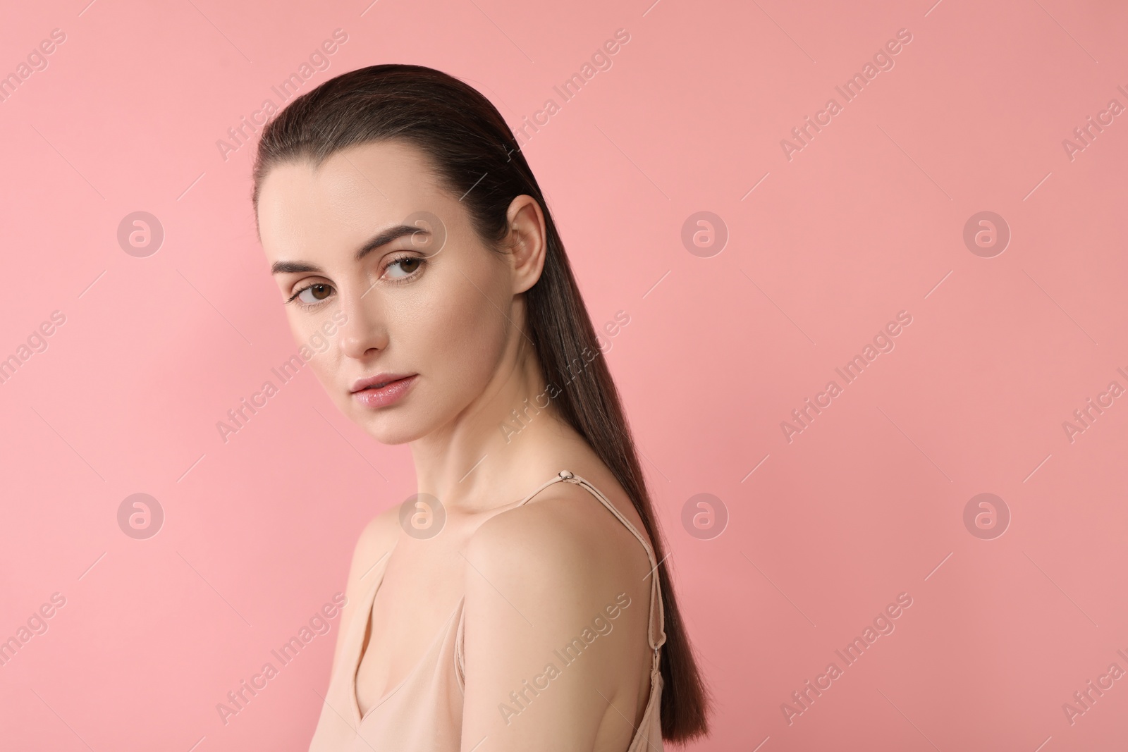 Photo of Portrait of beautiful young woman on pink background. Space for text