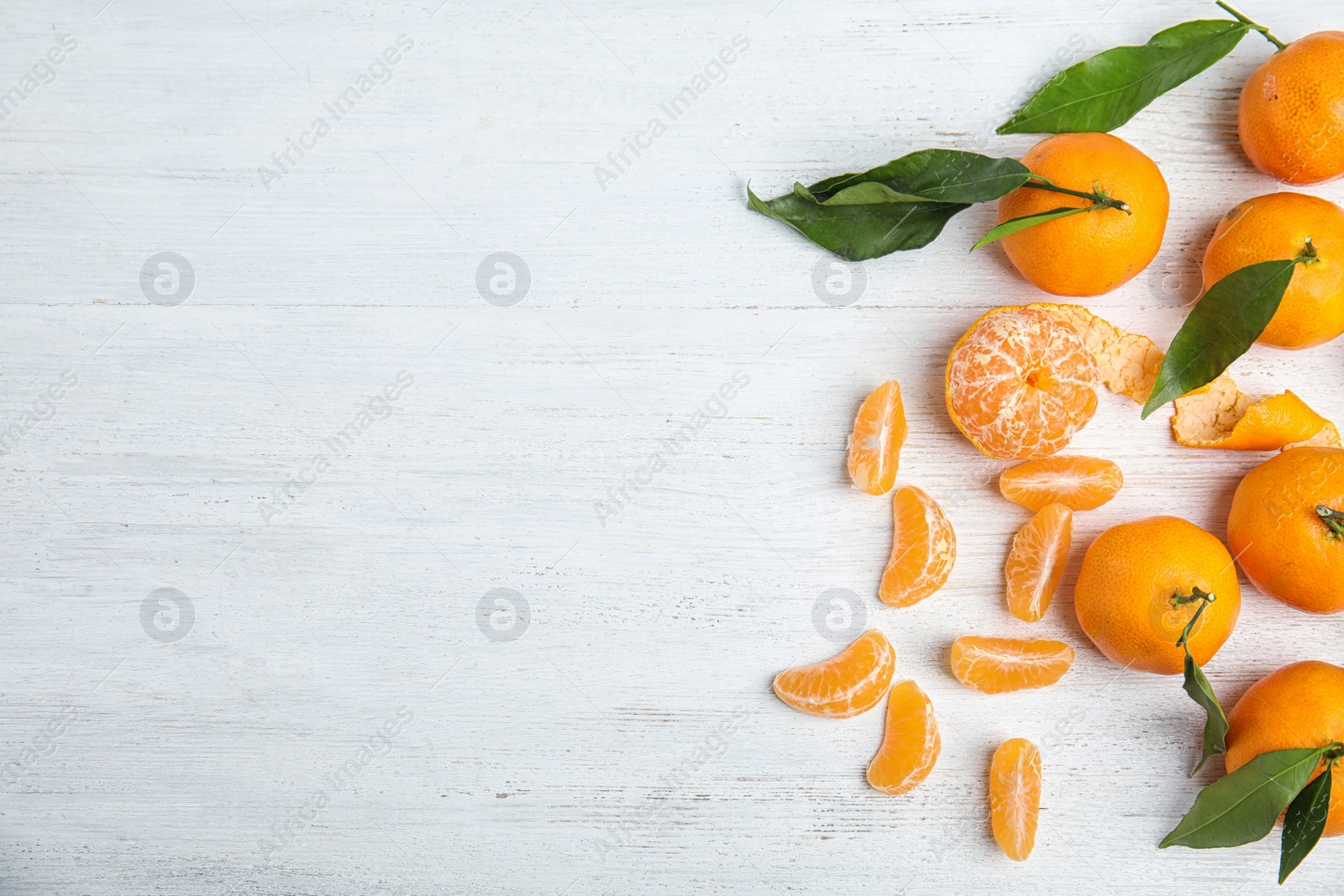 Photo of Fresh ripe tangerines and space for text on wooden background, top view