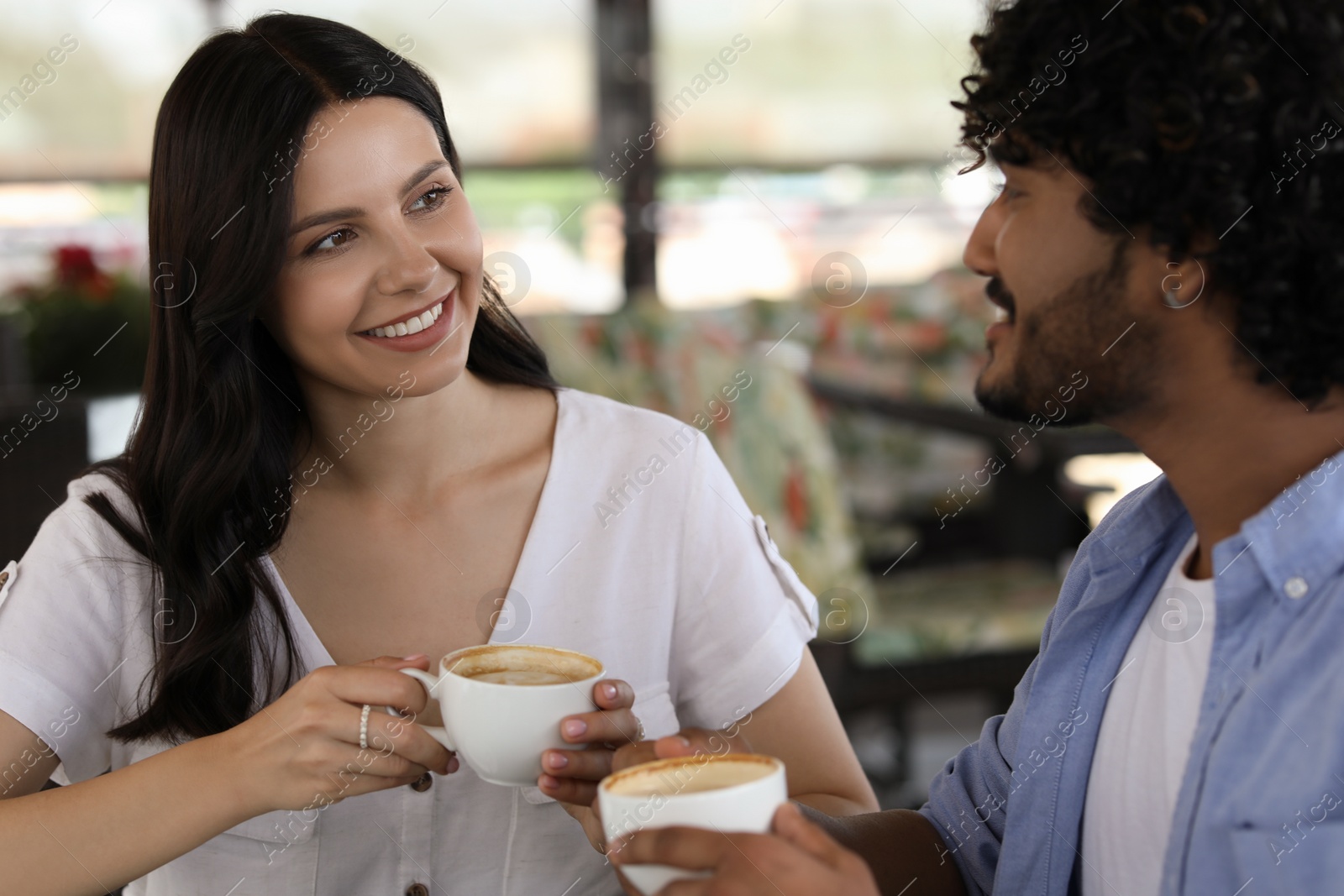 Photo of International dating. Happy couple enjoying tasty coffee in cafe