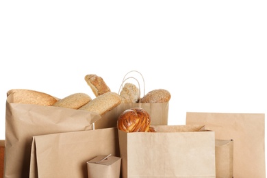 Different fresh bakery products in paper bags on white background
