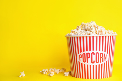 Photo of Tasty pop corn on yellow background. Space for text