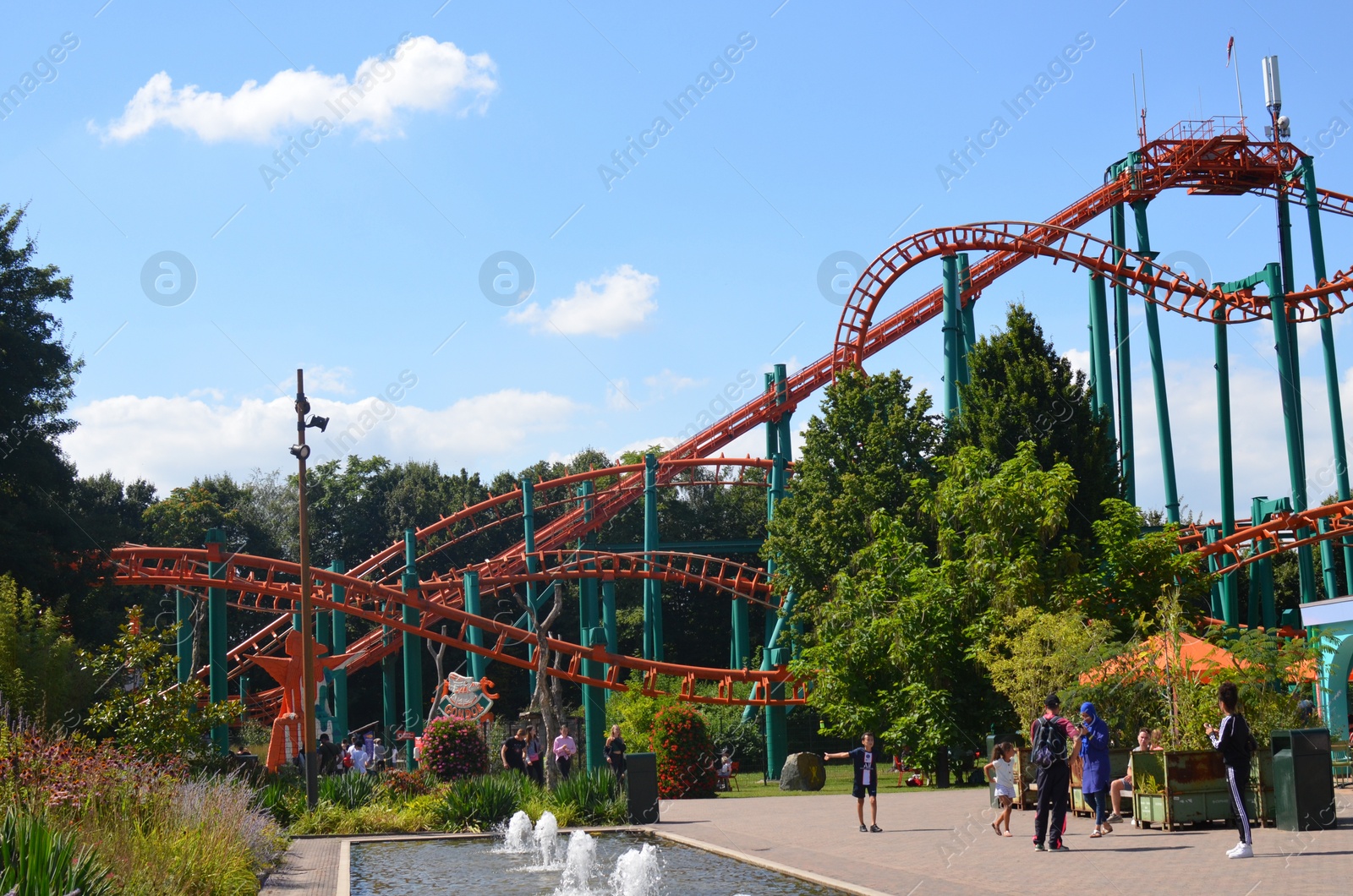 Photo of Amsterdam, The Netherlands - August 8, 2022: Large colorful rollercoaster and people walking in Walibi Holland amusement park