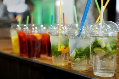 Photo of Plastic cups with refreshing drinks on bar counter