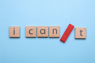 Motivation concept. Changing phrase from I Can't into I Can by adding slash symbol on light blue background, flat lay