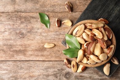 Photo of Flat lay composition with Brazil nuts and space for text on wooden background