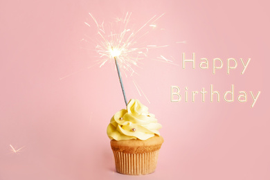 Image of Delicious cupcake with sparkler and text Happy Birthday on pale pink background