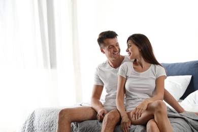 Happy couple wearing underwear in modern bedroom