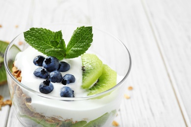 Photo of Tasty homemade granola dessert on white wooden table, closeup. Healthy breakfast