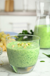 Photo of Green buckwheat smoothie on white marble table