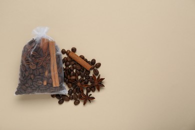 Photo of Scented sachet with coffee beans, anise and cinnamon on beige background, flat lay. Space for text