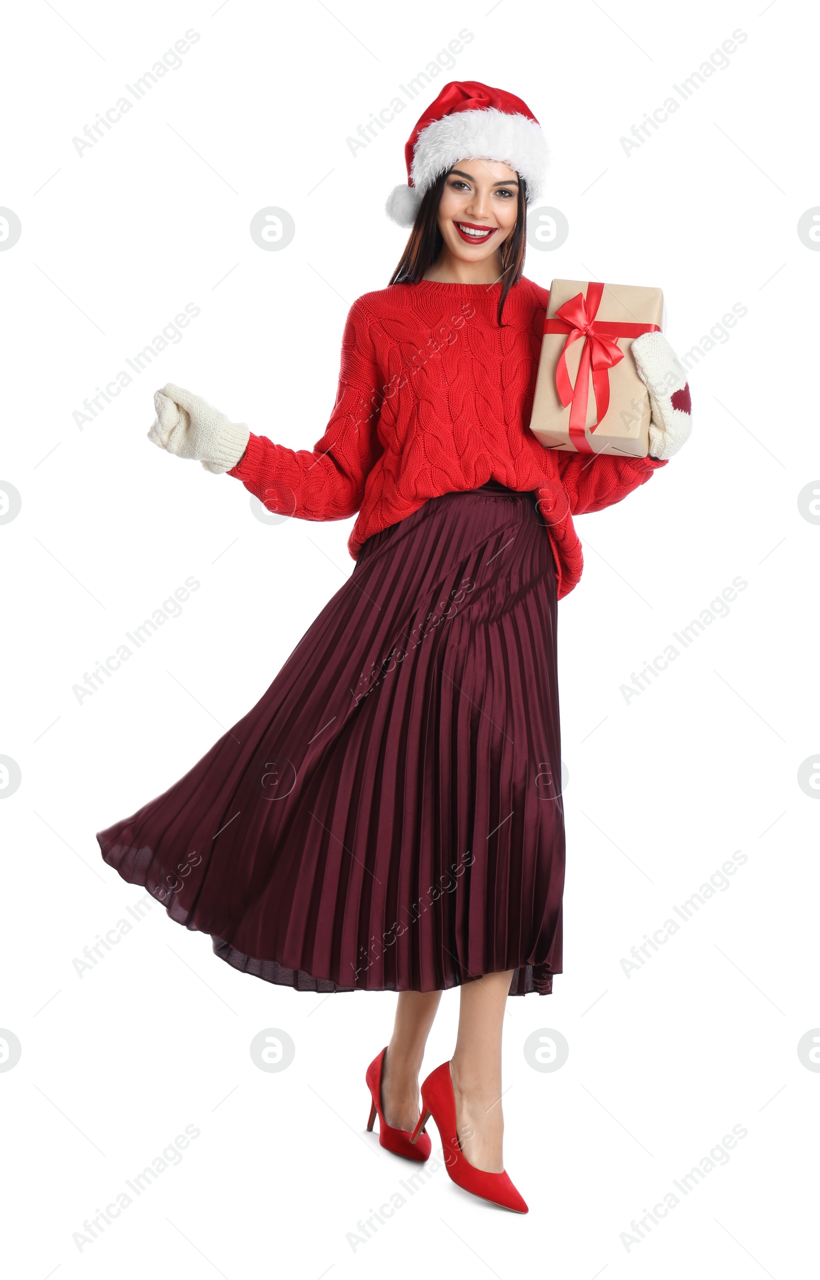 Photo of Woman in Santa hat, knitted mittens and red sweater holding Christmas gift on white background