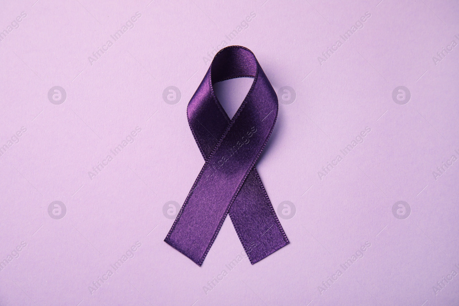 Photo of Purple ribbon on pink background, top view. Domestic violence awareness