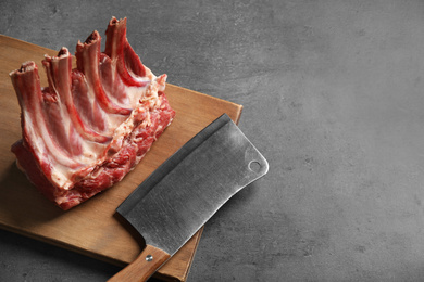 Photo of Raw ribs on grey table. Space for text