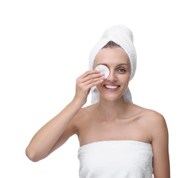 Young woman cleaning her face with cotton pad on white background