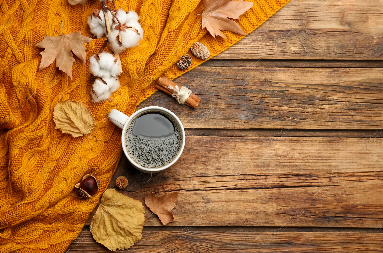 Photo of Flat lay composition with hot drink and warm plaid on wooden table, space for text