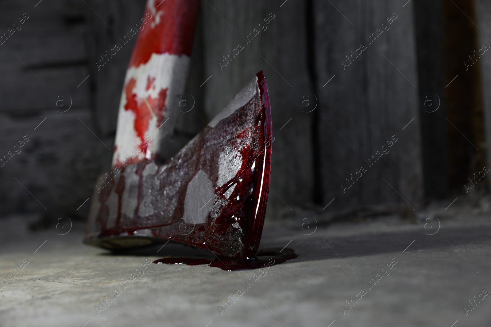 Photo of Axe with blood on floor indoors, closeup. Space for text