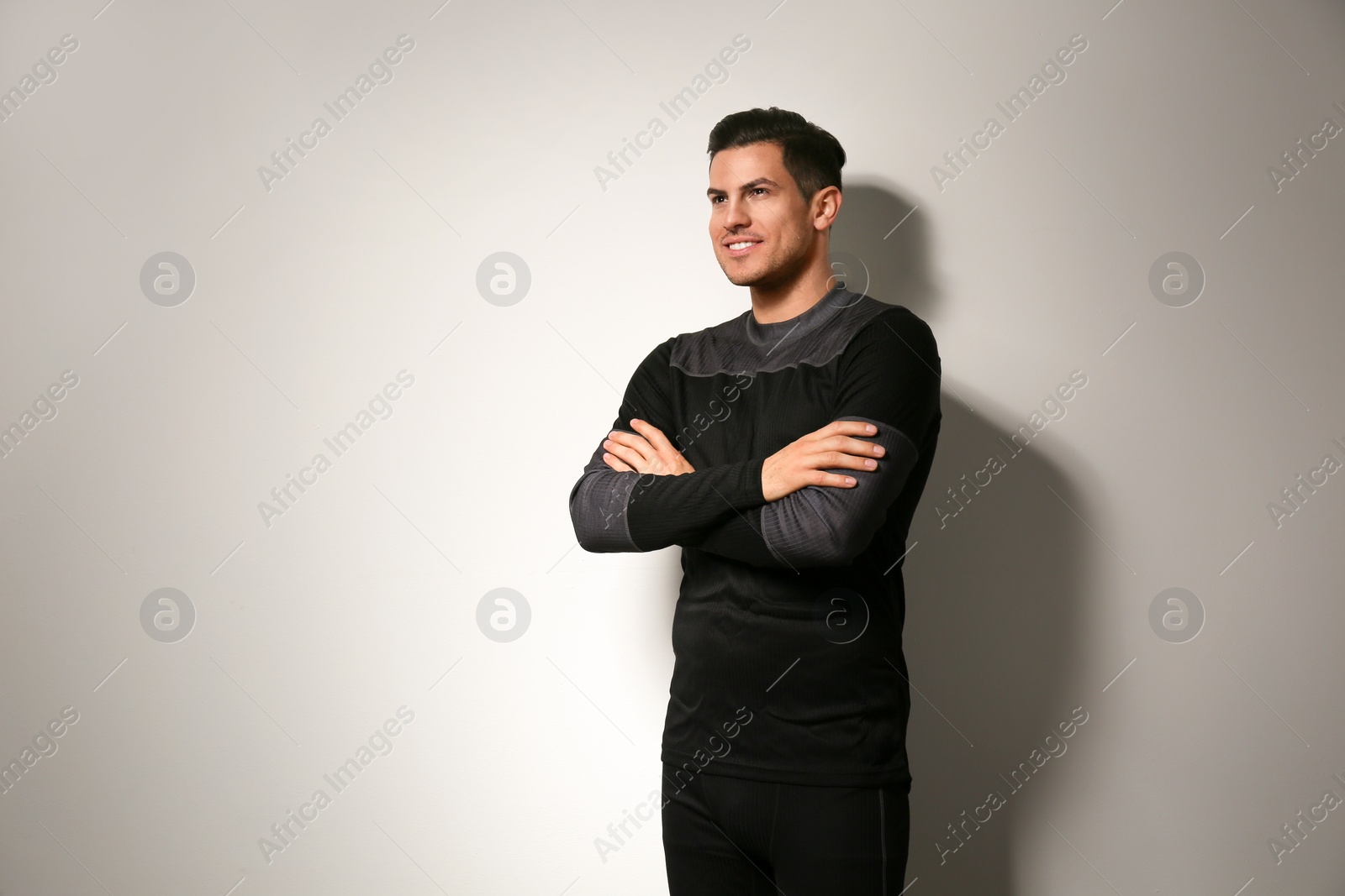 Photo of Man wearing thermal underwear on light grey background. Winter sport clothes