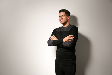 Photo of Man wearing thermal underwear on light grey background. Winter sport clothes