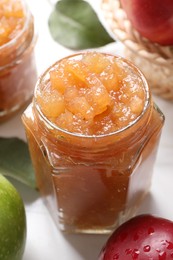 Photo of Delicious apple jam and fresh fruits on white table, closeup