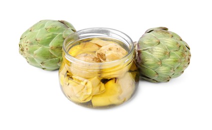 Photo of Open jar of delicious artichokes pickled in olive oil and fresh vegetables on white background