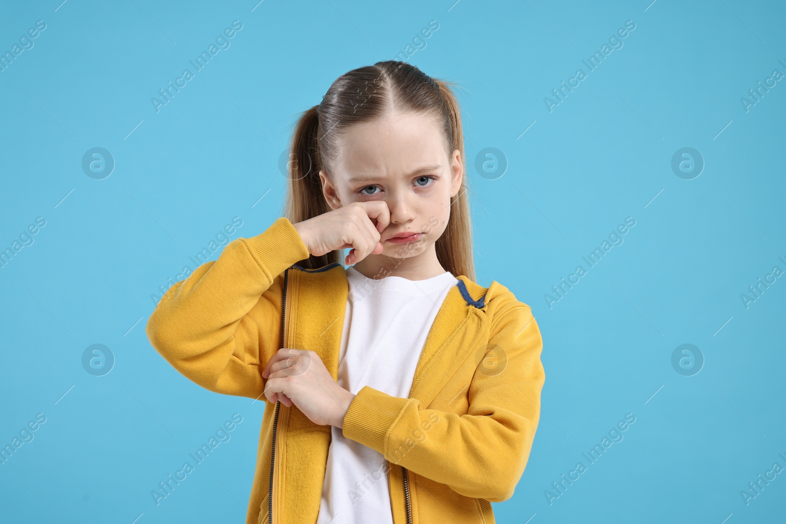 Photo of Portrait of sad girl on light blue background