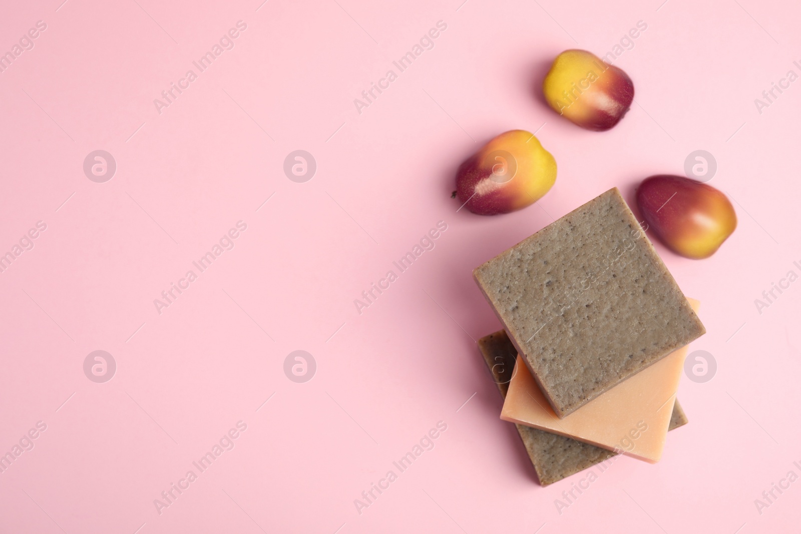 Image of Fresh ripe palm oil fruits and soap bars on pink background, flat lay. Space for text