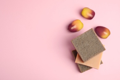 Fresh ripe palm oil fruits and soap bars on pink background, flat lay. Space for text