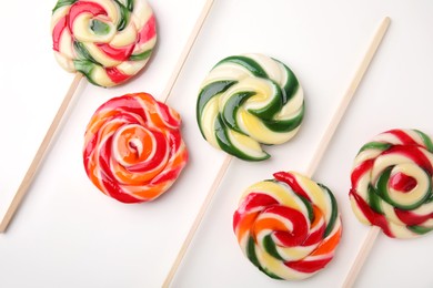 Photo of Many colorful lollipops on white background, flat lay