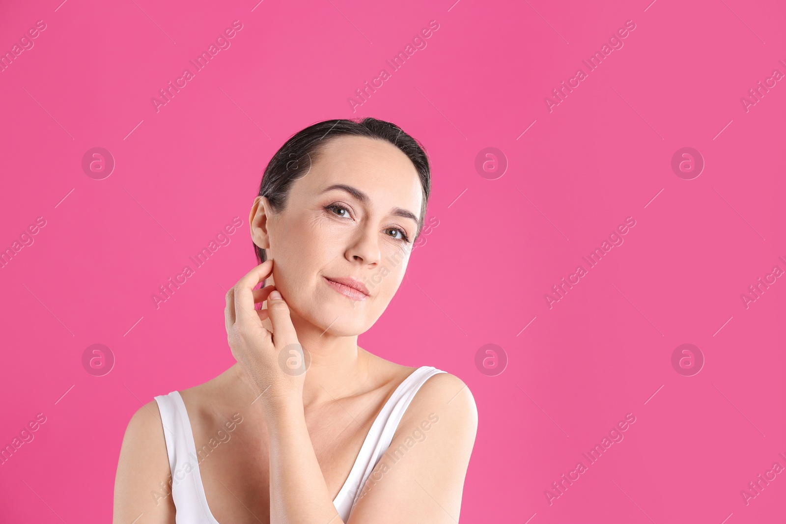 Photo of Portrait of beautiful mature woman on pink background. Space for text