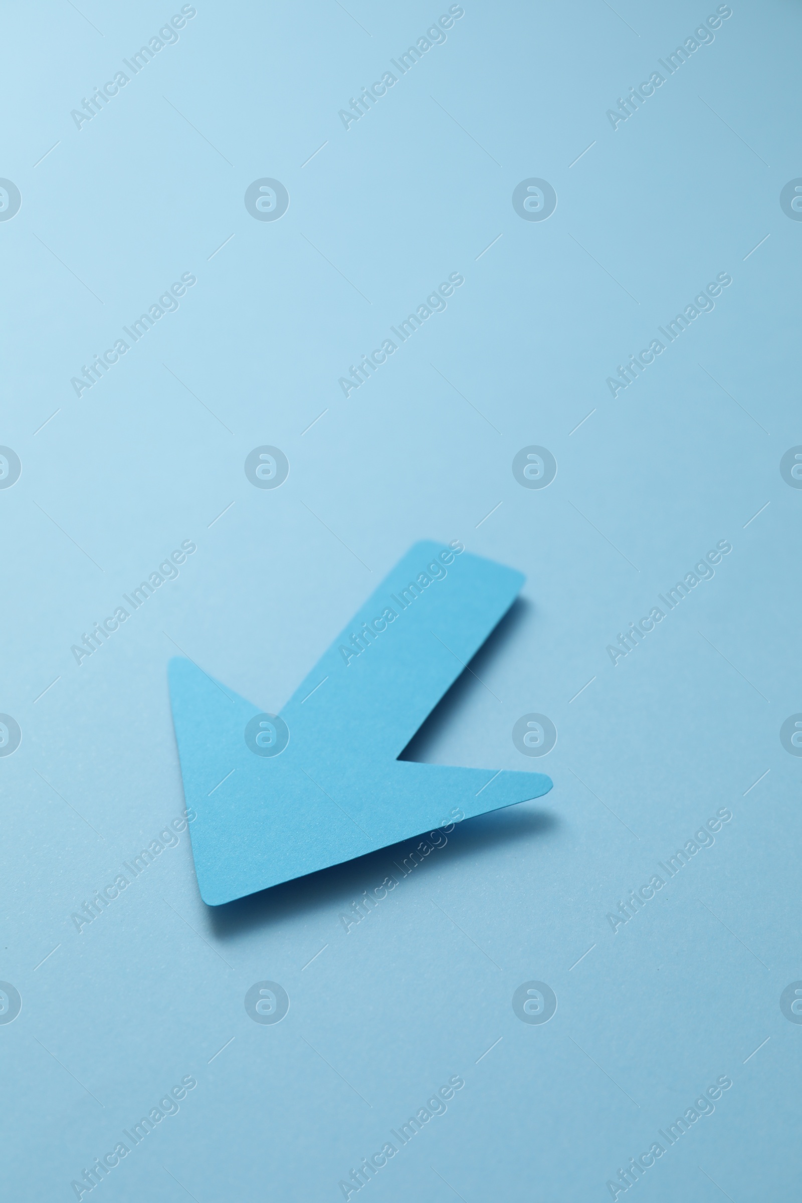 Photo of One paper arrow on light blue background,