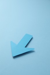 Photo of One paper arrow on light blue background,