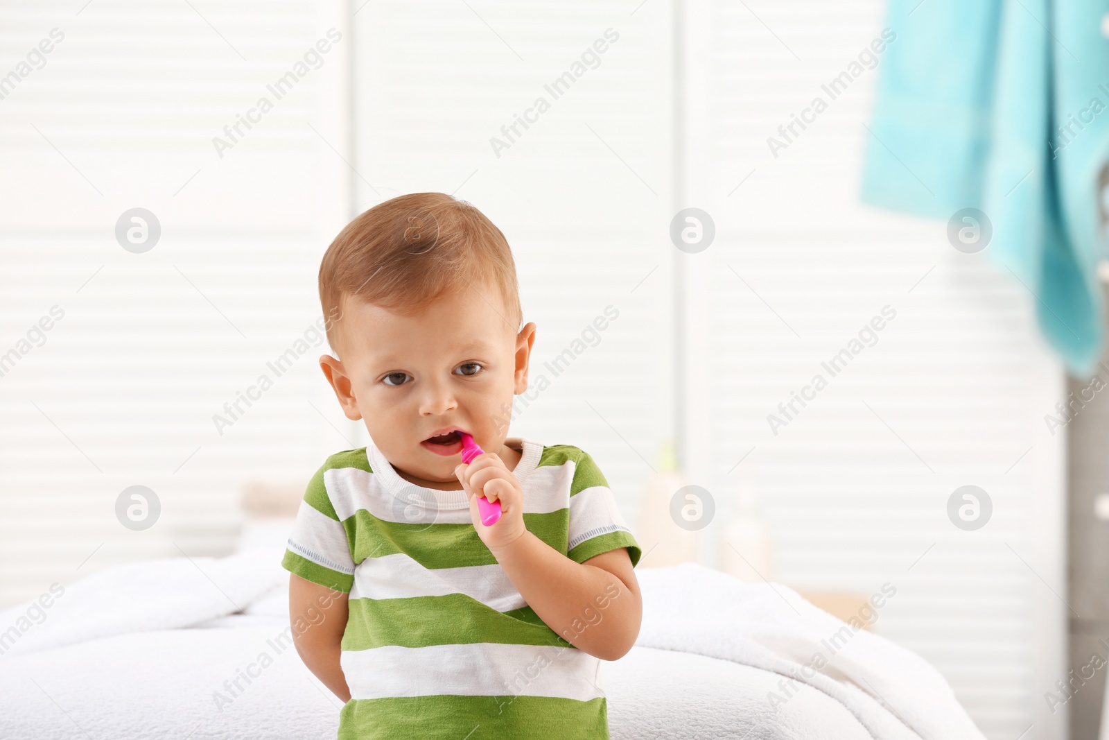 Photo of Cute little boy with toothbrush on blurred background