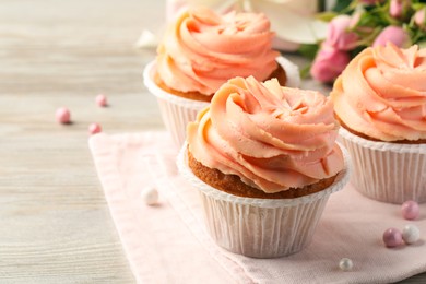Tasty cupcakes with cream on wooden table, closeup