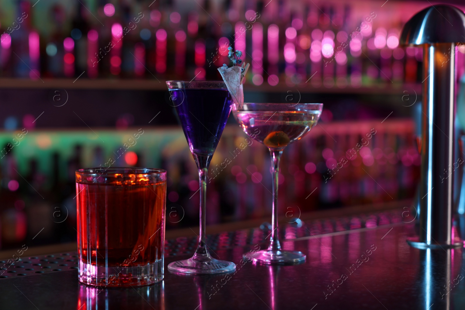 Photo of Different fresh alcoholic cocktails on counter in bar