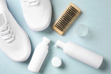 Photo of Flat lay composition with stylish footwear and shoe care accessories on light background