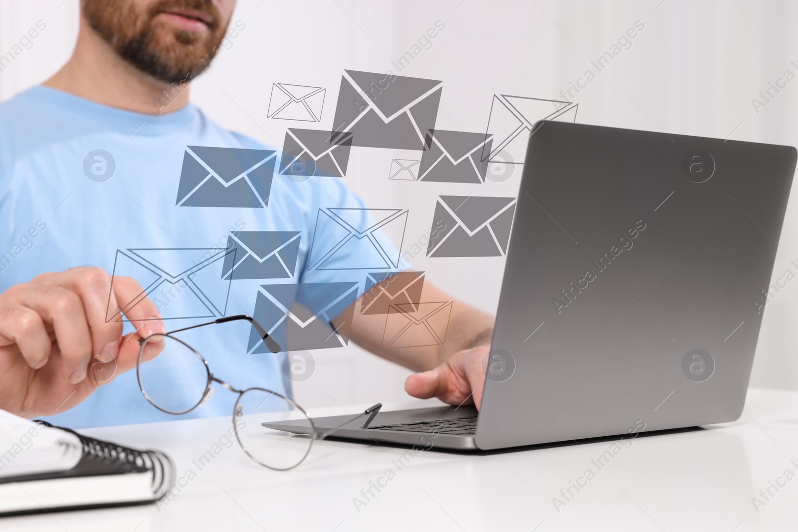 Image of Man typing on laptop at table indoors, closeup. Many illustrations of envelope as incoming messages over device