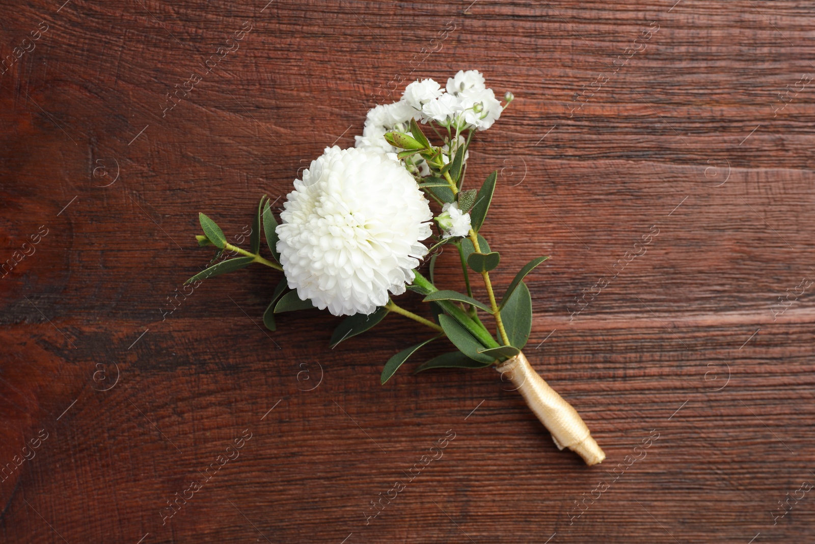 Photo of Small stylish boutonniere on wooden table, top view