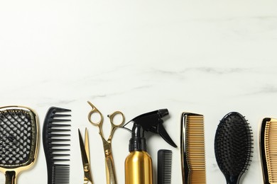 Hairdressing tools on white marble table, flat lay. Space for text