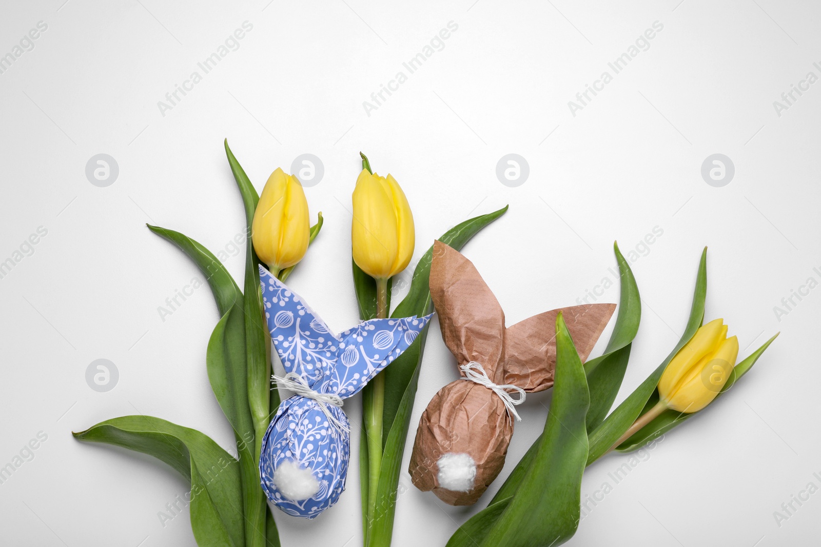 Photo of Flat lay composition with Easter bunnies made of paper and eggs on white background