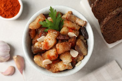 Photo of Tasty fried cracklings on light table, flat lay. Cooked pork lard