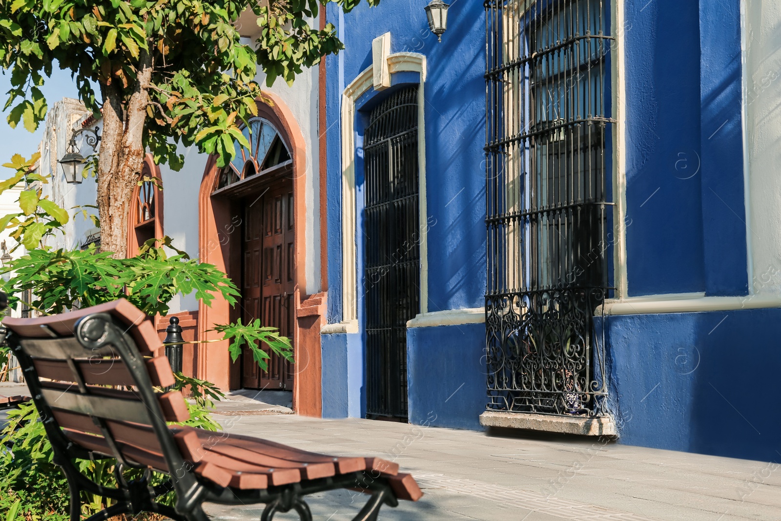 Photo of Wooden bench and buildings on city street